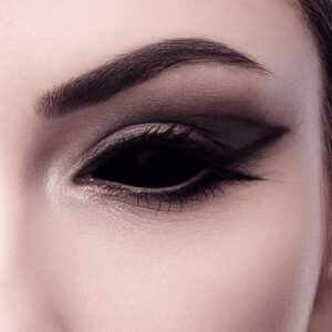 Close up of human eye with striking black full eye sclera contact lenses.