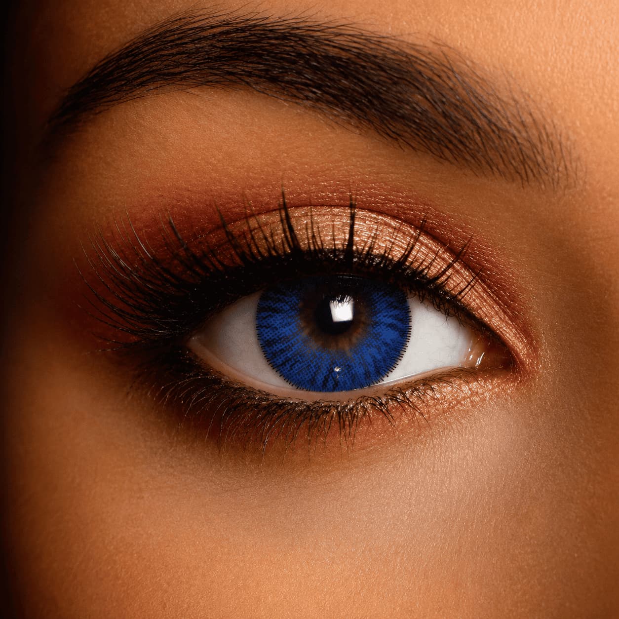 Close-up of an eye wearing natural circle blue contact lenses, featuring a rich sapphire-blue outer ring that enhances the iris with a larger, doll-eye effect while maintaining a realistic, blended appearance.