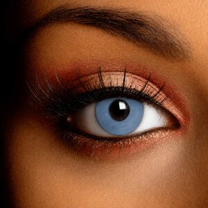 Close-up of an eye wearing Freaky Witch Contact Lenses, featuring a pale icy-grey opaque design that covers the natural iris.