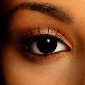 Close-up of a brown eye wearing Funky Black Contact Lenses, creating a dramatic all-black pupil effect.