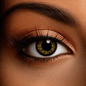 Close-up of an eye wearing Golden Vampire contact lenses with a dark black base and striking golden-yellow radial pattern around the pupil.